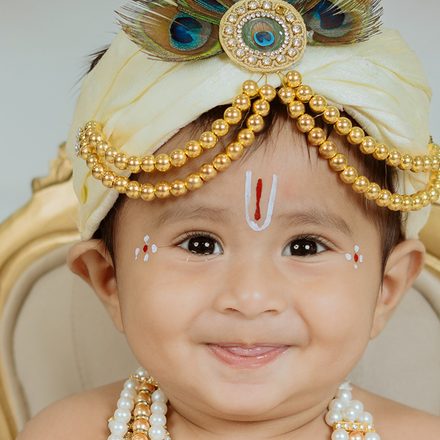 A child dressed as Krishna, looking up
