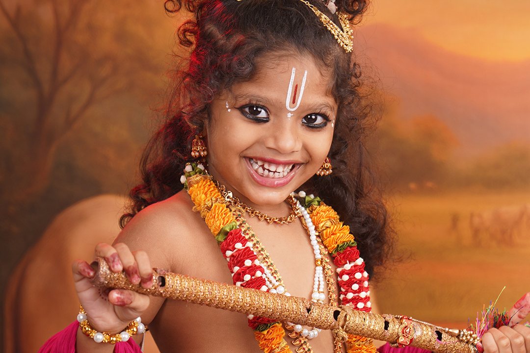 A child dressed as Krishna playing the flute