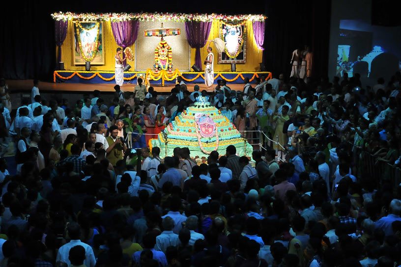 Devotees around Govardhana Cake